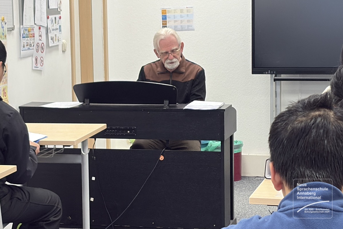 Bernd Barthel am Klavier im Musikunterricht mit Schülerinnen und Schülern